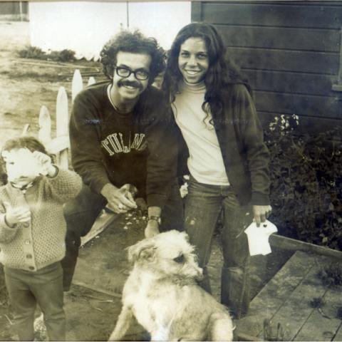 Black and white photo of a young Armand with his wife, daughter, and dog
